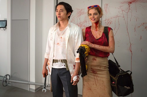 (L-R) Steven Yeun as Derek Cho and Samara Weaving as Melanie Cross in the horror, action film MAYHEM, an RLJE Films release. Photo courtesy of Sanja Bucko.