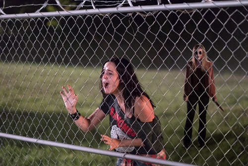 Kinsey (Bailee Madison) desperately tries to escape from Dollface (Emma Bellomy) in THE STRANGERS: PREY AT NIGHT. Photo credit: Brian Douglas / Aviron Pictures.